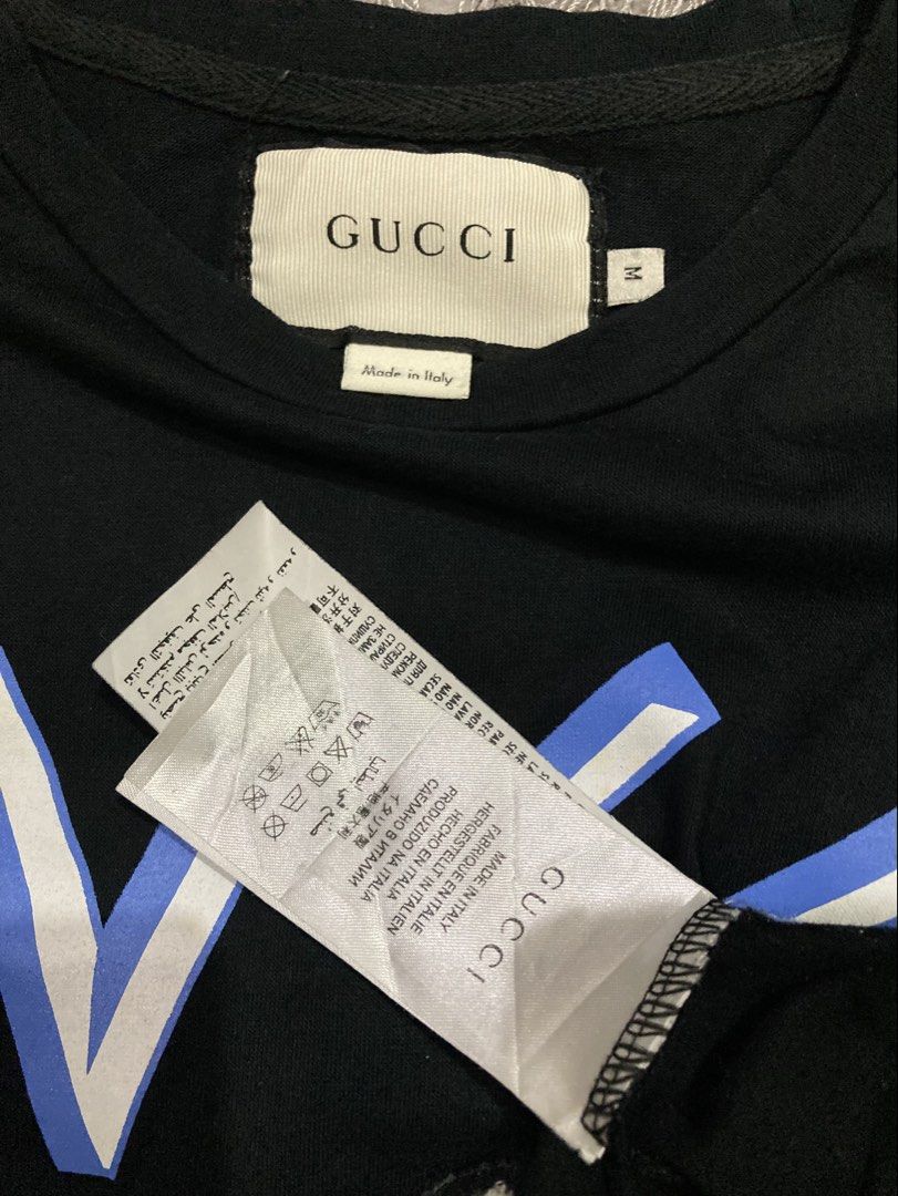 Gucci tshirt (Category: Luxury Apparel) located in General Santos City (Dadiangas). Submitted by amorhesthrift (Listing ID 1462381347, Image 3). Description: Like new condition Size-Medium on tag Dimes- W19.5 L24 This black short-sleeve T-shirt features a playful parody design combining a stylized Gucci-style logo, a fuzzy Donald Duck appliqué, and the Greek word for Serapis at the bottom.