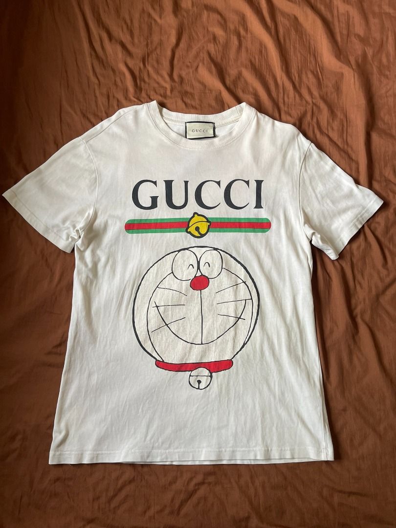 GUCCI x DORAEMON SHIRT (Category: Tshirts & Polo Shirts ) located in Manila. Submitted by ako.si.lemmor (Listing ID 1462291555, Image 1). Description: This item is off/legit since thrifted, manage your expectation. Dimes: 21X27 (L-XL) Color rate: 8.5/10 Issue: Cracked prints, slight fade Ship at your own cost or pickup Mandaluyong..