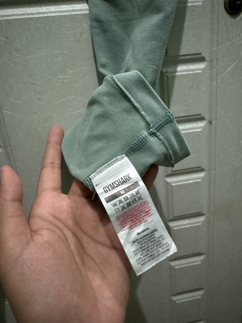 Gymshark Leggings Size M (Category: Activewear) located in Manila. Submitted by zennyaur (Listing ID 1462417791, Image 2). Description: - Brand: Gymshark - Color: Green - Style: Seamless Leggings - Fit: High-waisted - Size: Medium (M) - Material: Comfortable and stretchy - Origin: Made in Bangladesh - Versatile: Suitable for workouts or casual wear.
