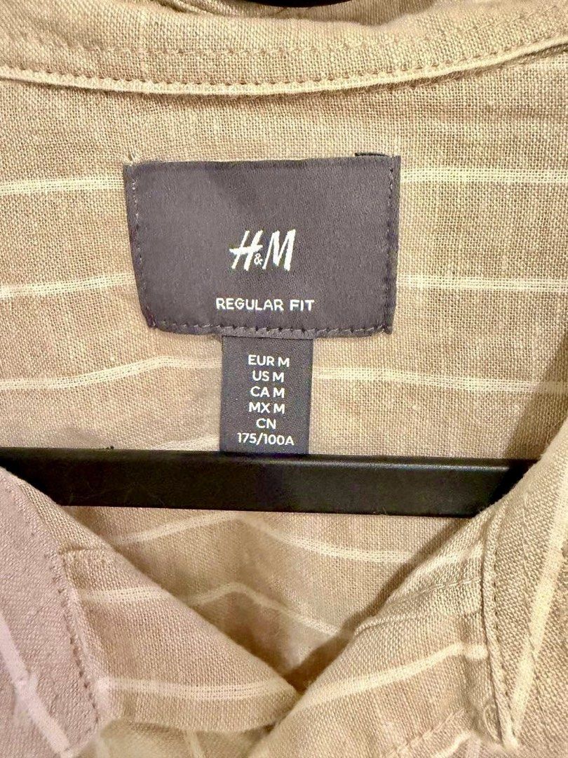 H&M Regular Fit Striped Shirt (Category: Tshirts & Polo Shirts ) located in Manila. Submitted by chris9837 (Listing ID 1462409858, Image 2). Description: - H&M shirt - Beige with thin white vertical stripes - Regular fit - Button-up front with a collar - Sleeves can be rolled up for versatility - Comfortable and casual style Location: Parañaque. .