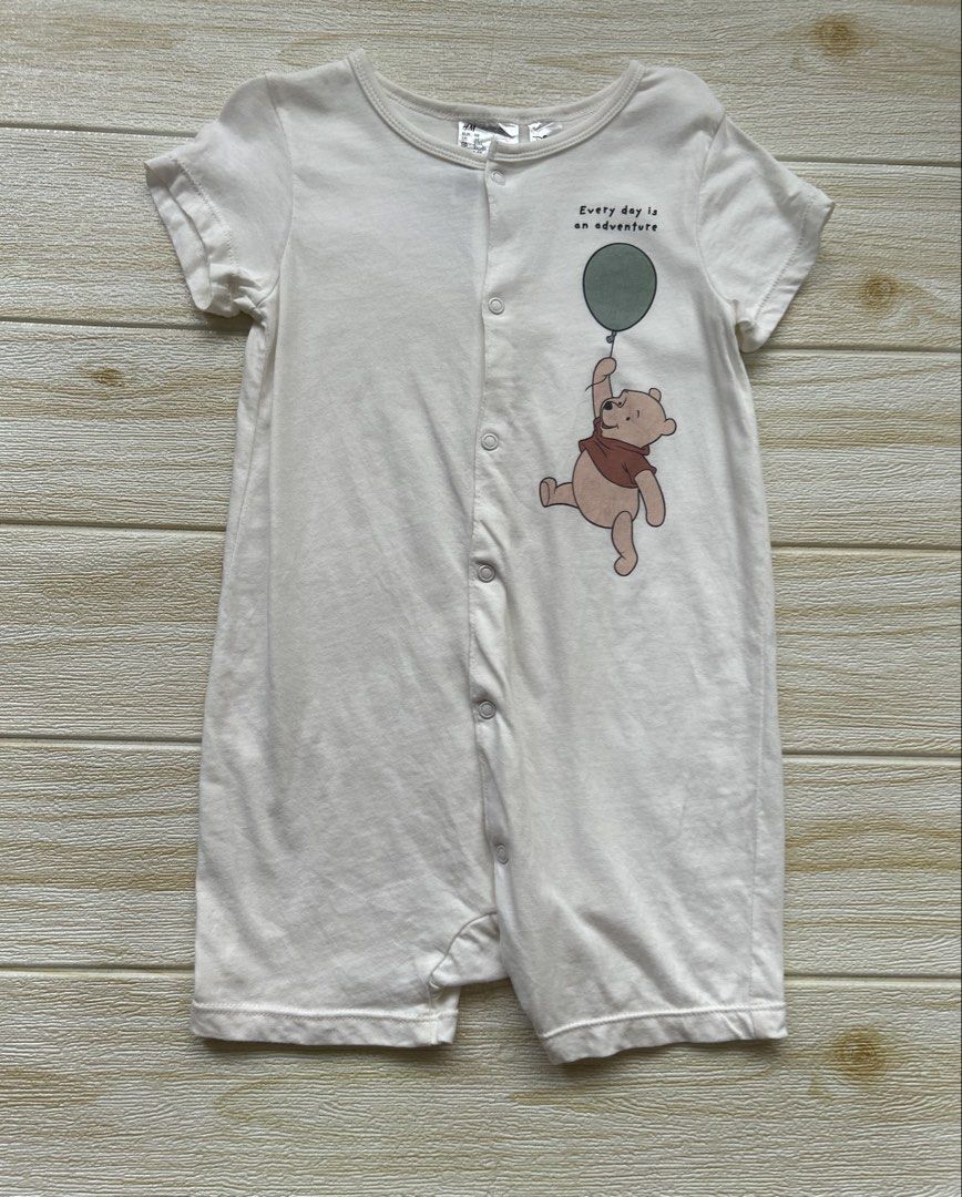 H&M white pooh romper (Category: Babies & Kids Fashion) located in Cebu City. Submitted by yjainani (Listing ID 1462350307, Image 1). Description: H&M white short-sleeved baby romper featuring a cute graphic of Winnie the Pooh holding a green balloon with the text "Every day is an adventure.