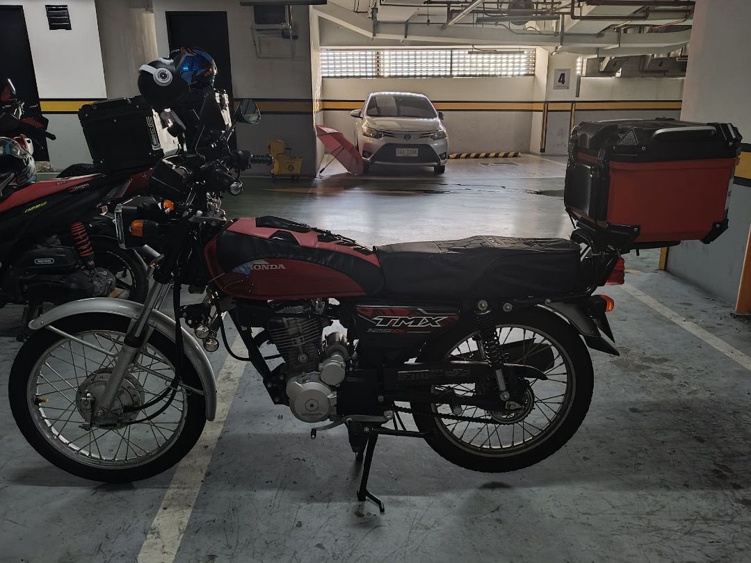 Honda Alpha 125 Motorcycle with Top Box (Category: Motorbikes for Sale) located in Caloocan City. Submitted by jaymarquit97387 (Listing ID 1462379987, Image 2). Description: Honda TMX 125 motorcycle for sale. Comes with a large red top box for storage. Odometer shows 9088 km. Ready for your daily rides or deliveries. Well-maintained and reliable. Contact me for more details..