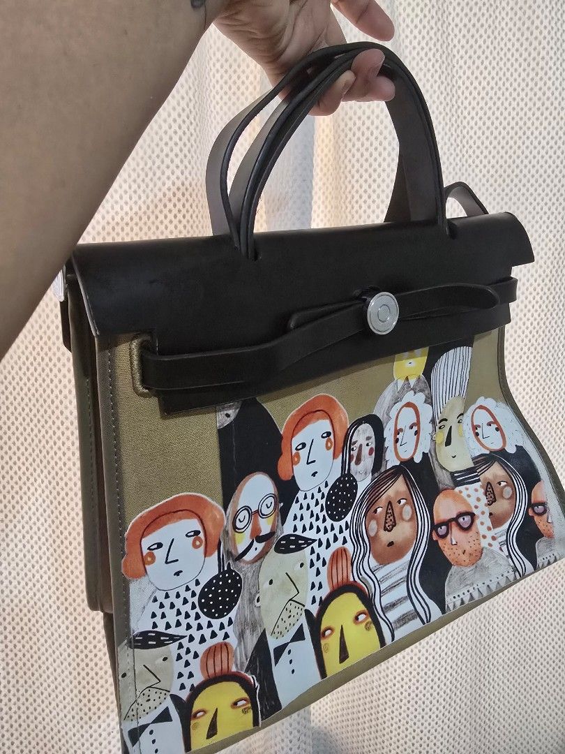Inspired Herbag (Category: Tote Bags) located in Mandaluyong City. Submitted by mariasdesire (Listing ID 1462295338, Image 1). Description: - Fun, artistic print of faces and dogs - Durable khaki canvas main body - Sturdy black leather handles - Secure strap closure with silver button - Spacious interior for all your essentials - Perfect for everyday use or as a unique statement piece.