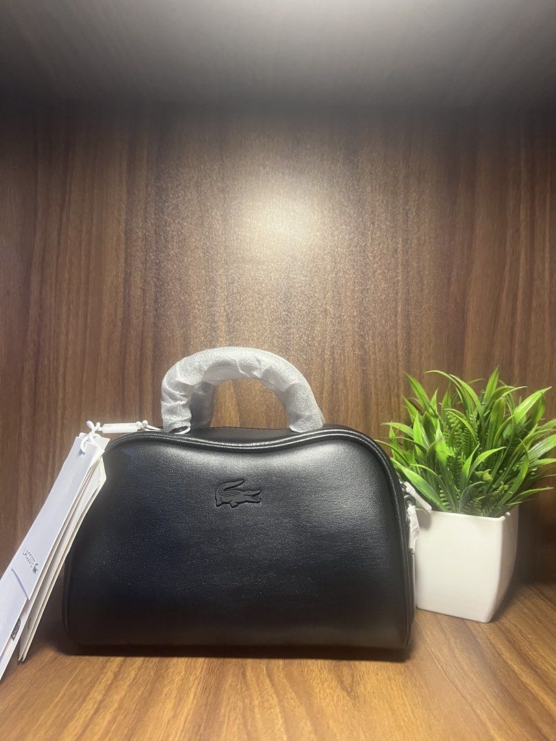 Lacoste Black Mini Lora Leather Purse Bag (Category: Luxury Bags & Wallets) located in Manila. Submitted by trustedceller (Listing ID 1462339021, Image 1). Description: Mini version of the iconic Lora purse. The contemporary design has space for your keys, phone, and billfold. Small in size, big on style! - Dimensions: L7 x H4.7 x D4.3”” / L18 x H12.5 x D11 cm -Recycled leather outer -Removable strap: 28” – 47” / 70cm – 120cm -2 handles -Tonal cr