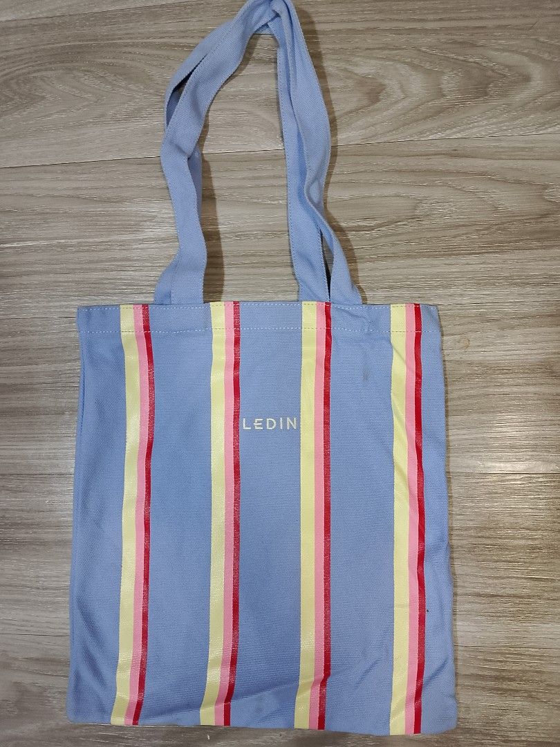 Ledin tote bag (Category: Tote Bags) located in Caloocan City. Submitted by pvaliao (Listing ID 1462361211, Image 2). Description: Brand: Ledin Fabric: Canvas cotton blend fabric Size: 14 inches × 16 inches Price: 100 pesos Pre-owned A light blue canvas tote bag from Ledin featuring multicolored stripes in yellow, pink and red, with dual shoulder strap. Buy it now!.