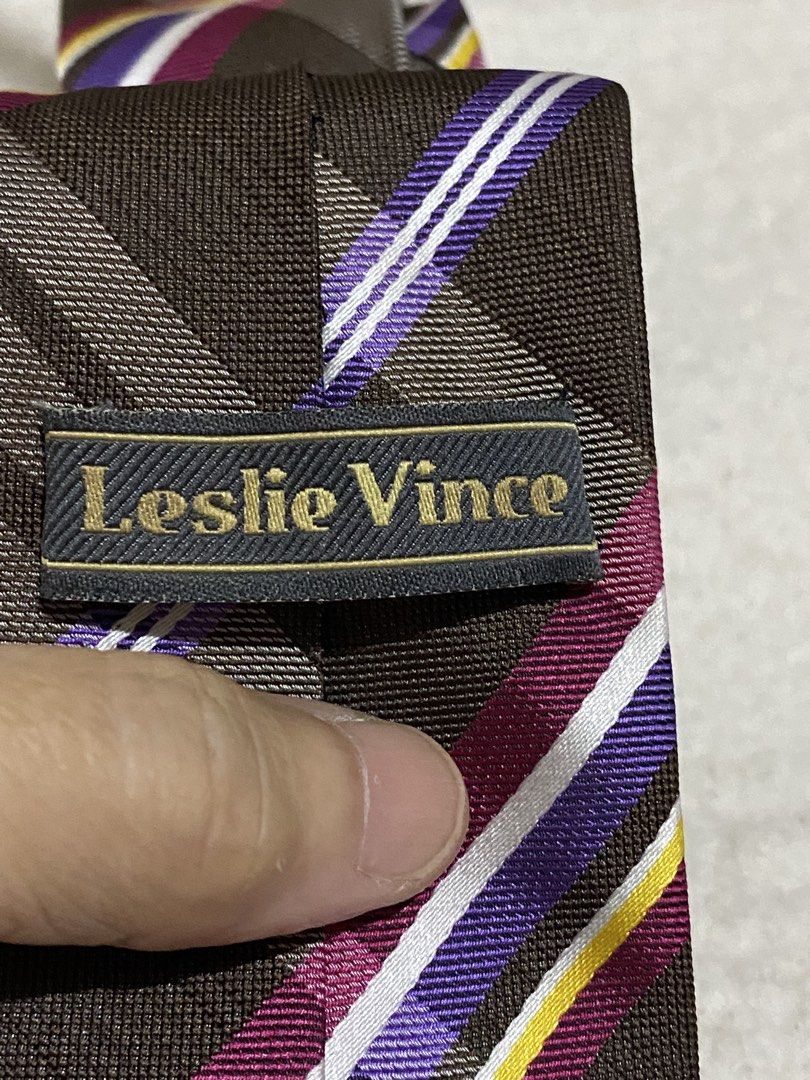 Leslie Vince Brown Plaid Necktie Microfiber (Category: Ties) located in Manila. Submitted by resi.diaz (Listing ID 1462349920, Image 3). Description: - Stylish brown necktie with a classic plaid pattern. - Features eye-catching stripes in purple, white, and yellow. - Crafted from durable and soft microfiber material. - Versatile design suitable for both formal events and casual outings..