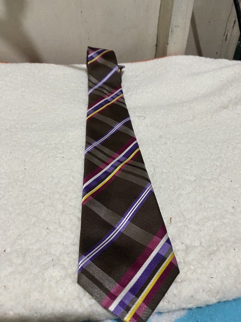Leslie Vince Brown Plaid Necktie Microfiber (Category: Ties) located in Manila. Submitted by resi.diaz (Listing ID 1462349920, Image 1). Description: - Stylish brown necktie with a classic plaid pattern. - Features eye-catching stripes in purple, white, and yellow. - Crafted from durable and soft microfiber material. - Versatile design suitable for both formal events and casual outings..