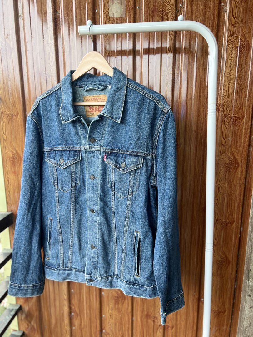 Levi's Trucker Denim Jacket Blue (Category: Coats, Jackets and Outerwear) located in Bago City. Submitted by g___shop (Listing ID 1462346019, Image 2). Description: - Classic Levi's denim jacket - Medium blue wash - Button front closure - Two chest pockets with button flaps - Side pockets - Standard collar - Estimated size: Large - Ideal for layering or standalone wear - Versatile wardrobe staple.