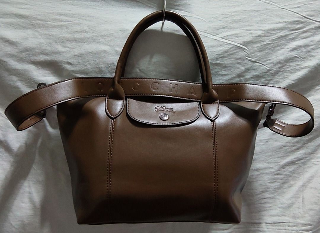 Longchamp Le Pliage Cuir Top Handle Bag (Category: Luxury Bags & Wallets) located in Caloocan City. Submitted by jpmshoppe (Listing ID 1462282617, Image 1). Description: - Authentic Longchamp handbag - Rich brown leather - Versatile: Top handles and detachable shoulder strap - Secure closure: Zipper with snap button flap - Crafted in France - Ideal everyday bag.