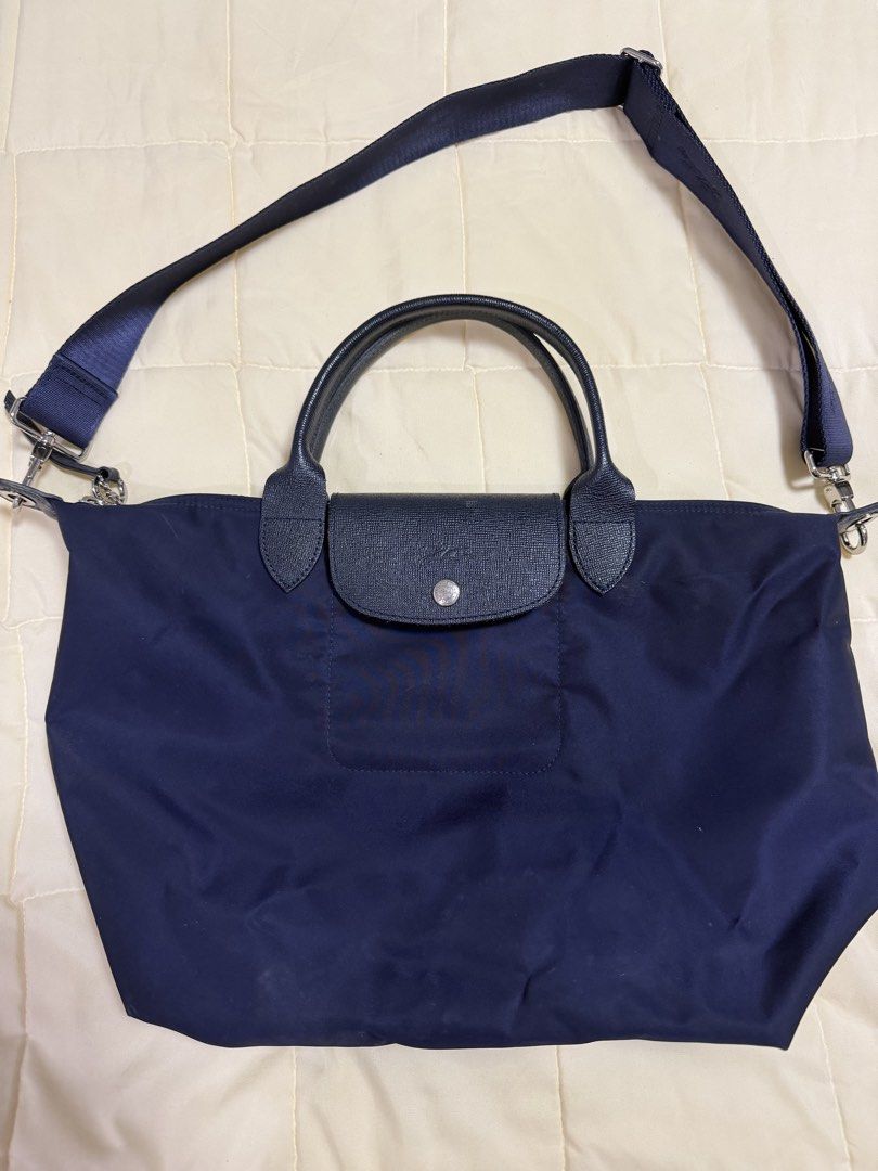 Longchamp Le Pliage Neo Navy Blue Top Handle Bag (Category: Luxury Bags & Wallets) located in Paranaque City. Submitted by kimgcham (Listing ID 1462374849, Image 1). Description: - Navy blue Longchamp bag - Durable nylon material with leather handles and trim - Secure top zip closure with snap button flap - Detachable shoulder strap for versatile carrying - Interior pocket for essentials - Ample space, perfect for daily use or travel.