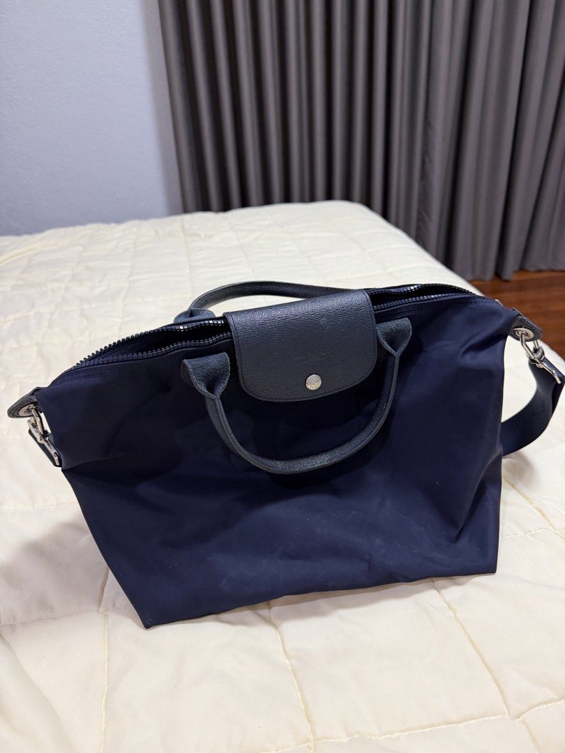 Longchamp Le Pliage Neo Navy Blue Top Handle Bag (Category: Luxury Bags & Wallets) located in Paranaque City. Submitted by kimgcham (Listing ID 1462374849, Image 2). Description: - Navy blue Longchamp bag - Durable nylon material with leather handles and trim - Secure top zip closure with snap button flap - Detachable shoulder strap for versatile carrying - Interior pocket for essentials - Ample space, perfect for daily use or travel.