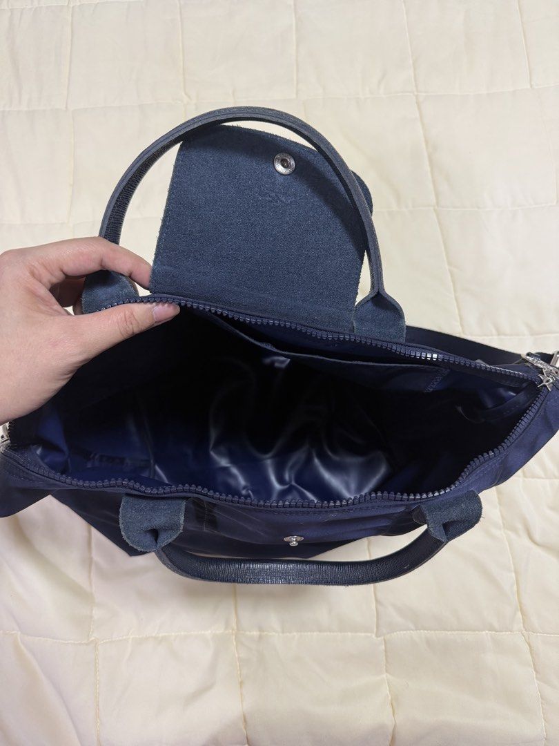 Longchamp Le Pliage Neo Navy Blue Top Handle Bag (Category: Luxury Bags & Wallets) located in Paranaque City. Submitted by kimgcham (Listing ID 1462374849, Image 3). Description: - Navy blue Longchamp bag - Durable nylon material with leather handles and trim - Secure top zip closure with snap button flap - Detachable shoulder strap for versatile carrying - Interior pocket for essentials - Ample space, perfect for daily use or travel.