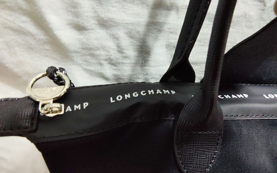 Longchamp Le Pliage Tote Bag (Category: Luxury Bags & Wallets) located in Caloocan City. Submitted by jpmshoppe (Listing ID 1462283318, Image 2). Description: - Classic black Longchamp tote bag - Durable nylon body with genuine leather handles and trim - Features the iconic Longchamp horse logo - Authentically Made in France - Ample interior space for all your essentials - Ideal for everyday use and travel.