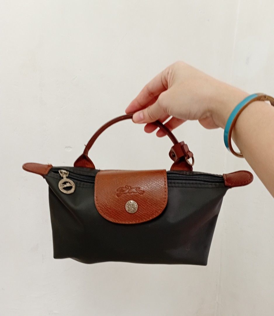 Longchamp Mini Pouch /Crossbody bag (Category: Purses & Pouches) located in Navotas City. Submitted by riyuwi (Listing ID 1462354717, Image 1). Description: PreOwned lightly Used Longchamp Pouch Mini hand/Crossbody bag - Elegant Brown Leather Trim & Handle - Detachable Shoulder Strap for Versatility - Secure Zipper Closure - Stylish Gold Hardware - Ideal for organizing essentials or as a standalone clutch XXS -Micro Sized Sign of Used sa detachab