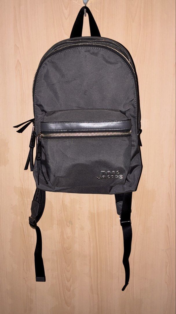 Marc Jacobs Black Nylon Backpack (Category: Backpacks) located in Placer. Submitted by talaalond61563 (Listing ID 1462277169, Image 1). Description: - Classic gray Marc Jacobs backpack - Durable nylon material - Front zip pocket and main compartment - Silver-tone hardware with subtle branding - Adjustable shoulder straps for comfort - Ideal for everyday use or travel.
