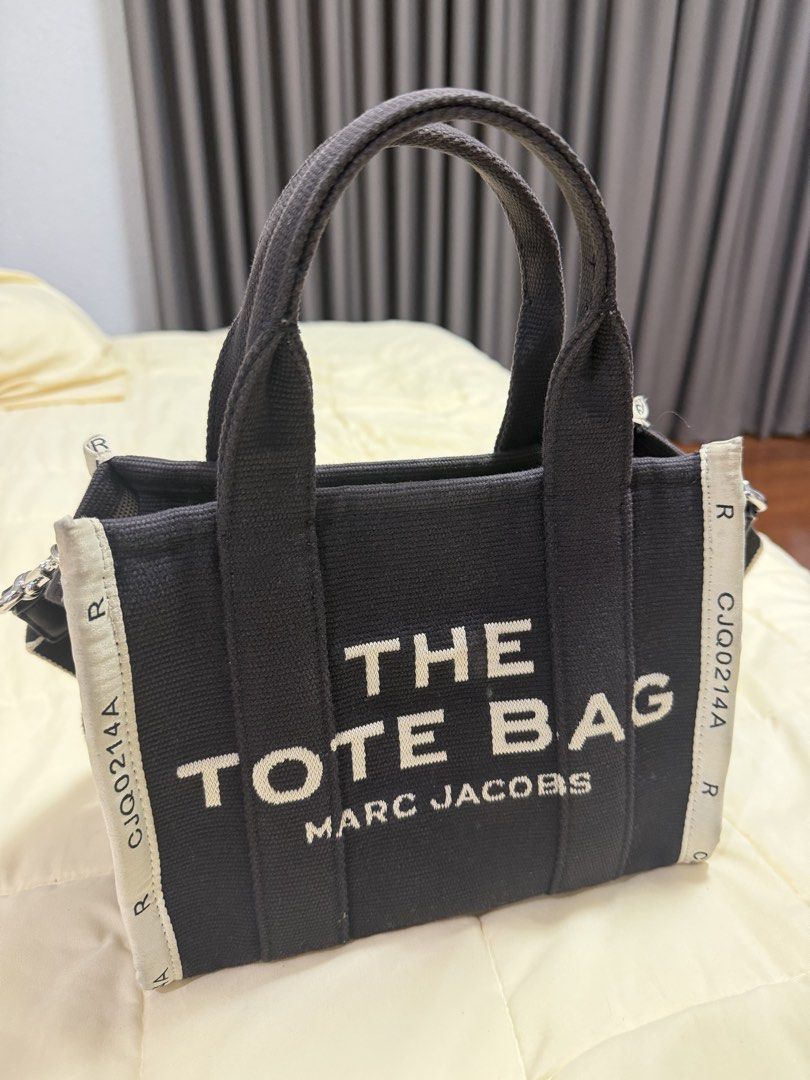 Marc Jacobs The Tote Bag Black Canvas (Category: Luxury Bags & Wallets) located in Paranaque City. Submitted by kimgcham (Listing ID 1462378888, Image 2). Description: - Authentic Marc Jacobs "The Tote Bag" - Durable black canvas material - Versatile crossbody option with included long strap - Immaculate and clean interior - Ideal for everyday essentials and errands.