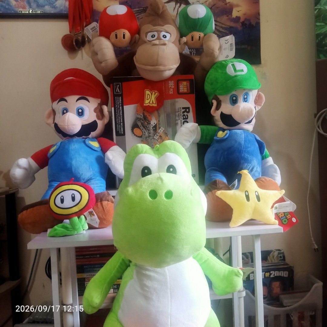 Mario and luigi etc. Plushie (Category: Plushies & Soft Toys) located in Manila. Submitted by yaaaaaj- (Listing ID 1462313582, Image 2). Description: Mario: Large plush wearing his classic red hat and blue overalls. Luigi: Large plush wearing a green hat and matching blue overalls. Yoshi: Large green and white dinosaur plush sitting at the front. Donkey Kong: Brown plush positioned on the upper shelf. Diddy Kong: Smaller brown plush with a red ca