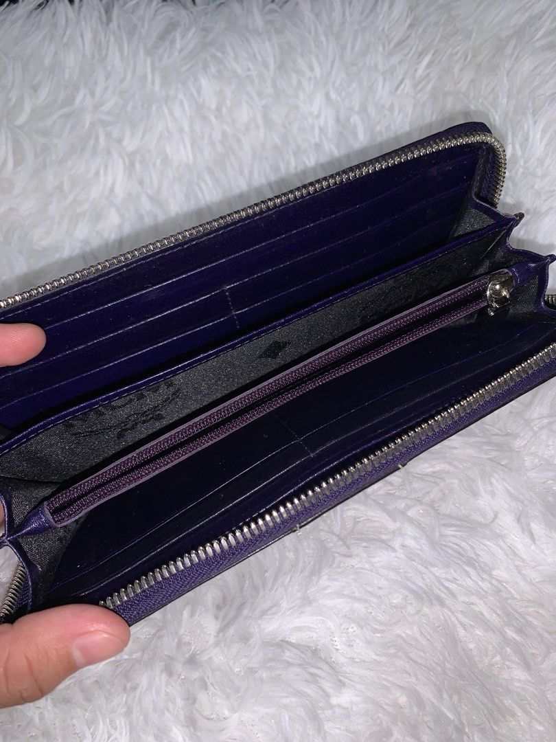 MCM wallet (Category: Wallets & Card holders) located in Manila. Submitted by bloobellyyy (Listing ID 1462265584, Image 2). Description: Style: Zip-around long wallet or organizer Material & Color: Smooth, dark black leather Design Details: Vertical central panel with white contrast stitching and a signature silver- or gold-toned metal MCM logo plaque on the front Closure: Full perimeter zipper to keep contents secure.