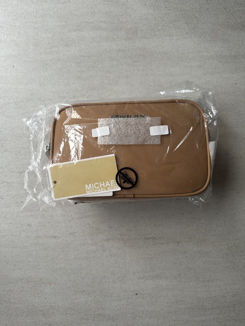 Michael Kors Brown Leather Sling Pouch (Category: Purses & Pouches) located in Manila. Submitted by sweetgrass.shark (Listing ID 1462297075, Image 2). Description: - MK Pouch - Color: Tan/Brown/Peanut - Zipper closure - Interior features Michael Kors branding - Comes with original tags and packaging - Ideal for organizing essentials or as a small travel bag *added image from MK website for body-size reference RFS: decluttering, unused gift Pickup