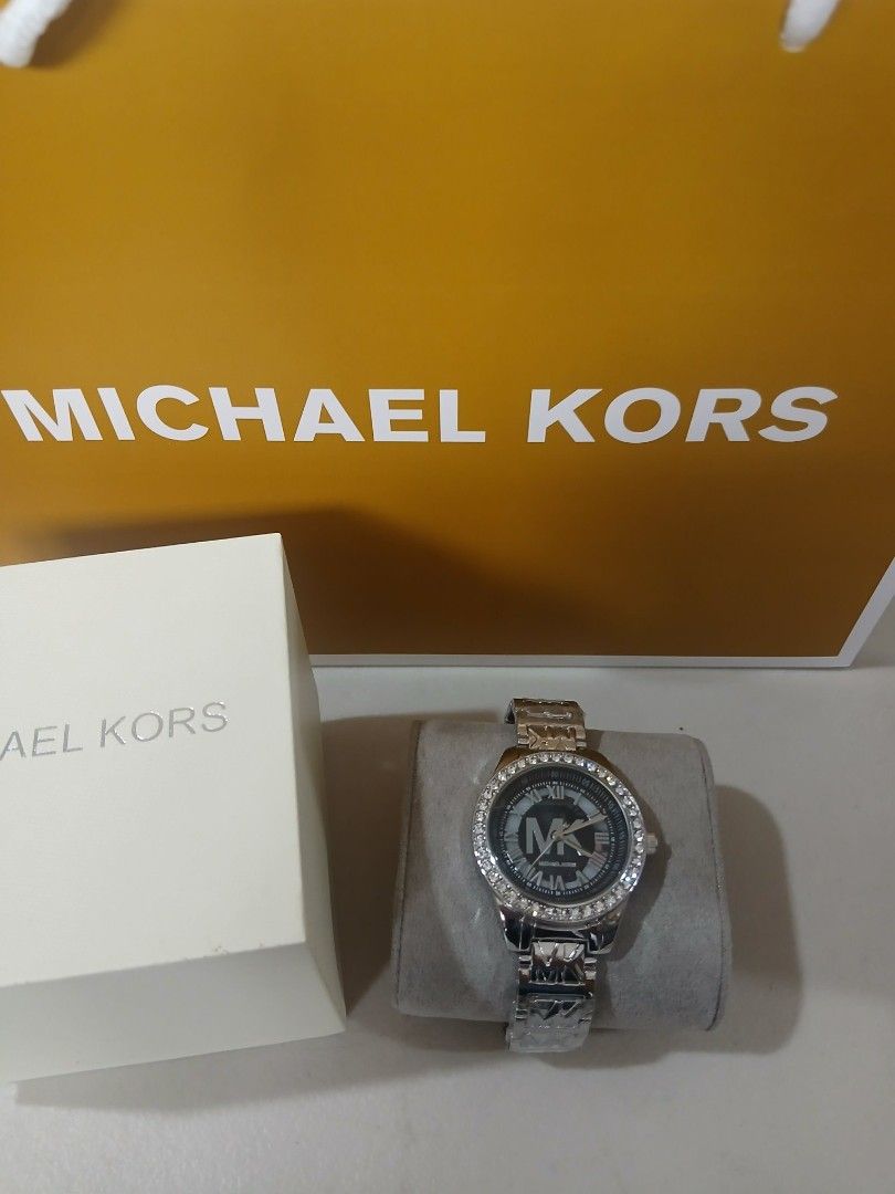 Michael Kors Watch with Crystal Bezel (Category: Women's Watches) located in Manila. Submitted by alegriacyr19 (Listing ID 1462322625, Image 1). Description: - Top Grade Watch - Authentic Michael Kors watch - Elegant silver-tone metal band - Classic black dial featuring Roman numerals and iconic MK logo - Sparkling crystal-embellished bezel - Comes with original box and dust bag - Perfect statement accessory to elevate any outfit.