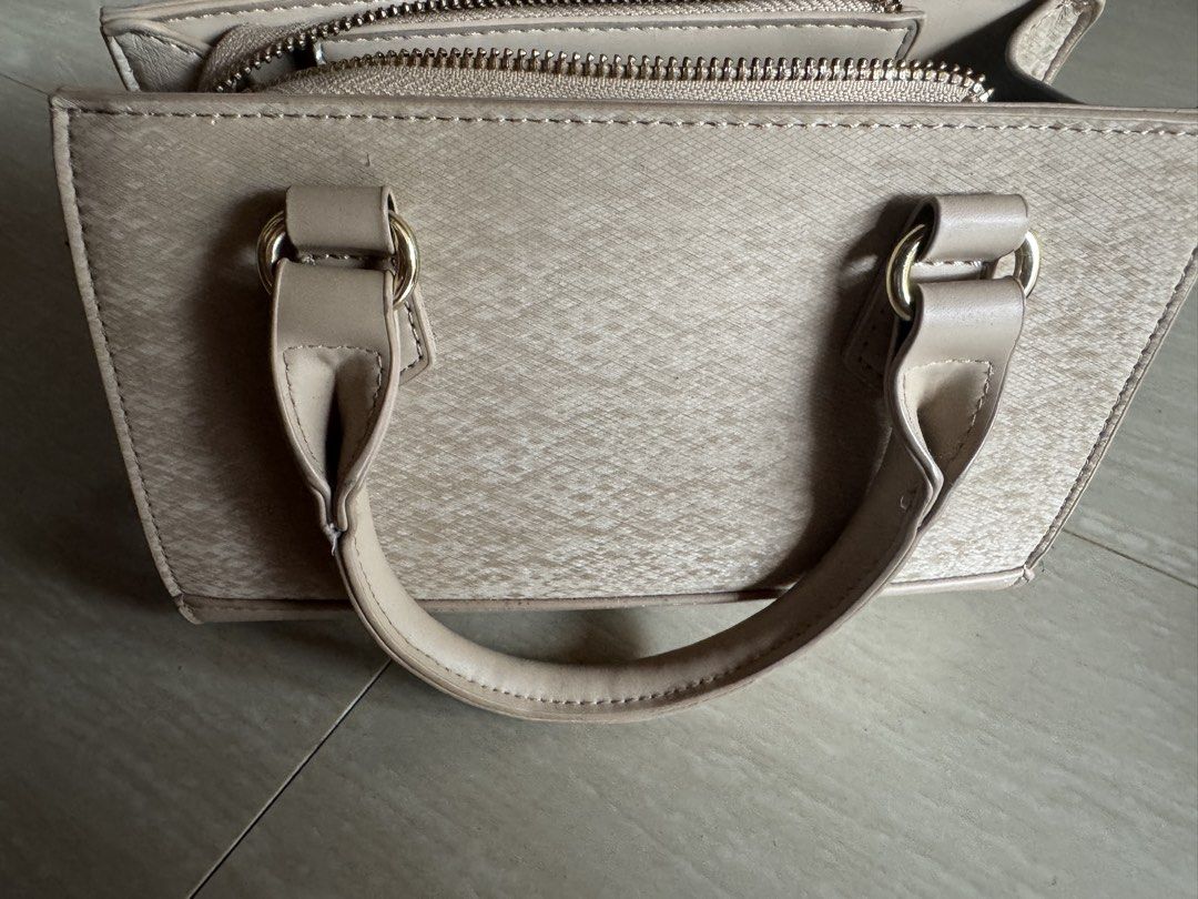 MICHAELA Beige Textured Top Handle Bag with Strap (Category: Cross-body Bags) located in Valenzuela. Submitted by tricegonzales (Listing ID 1462335999, Image 2). Description: - Brand: MICHAELA - Color: Beige - Material: Textured - Features: Top handles, detachable shoulder strap, zipper closure - Hardware: Gold details - Interior: Spacious, fits essentials - Ideal for: Everyday use.