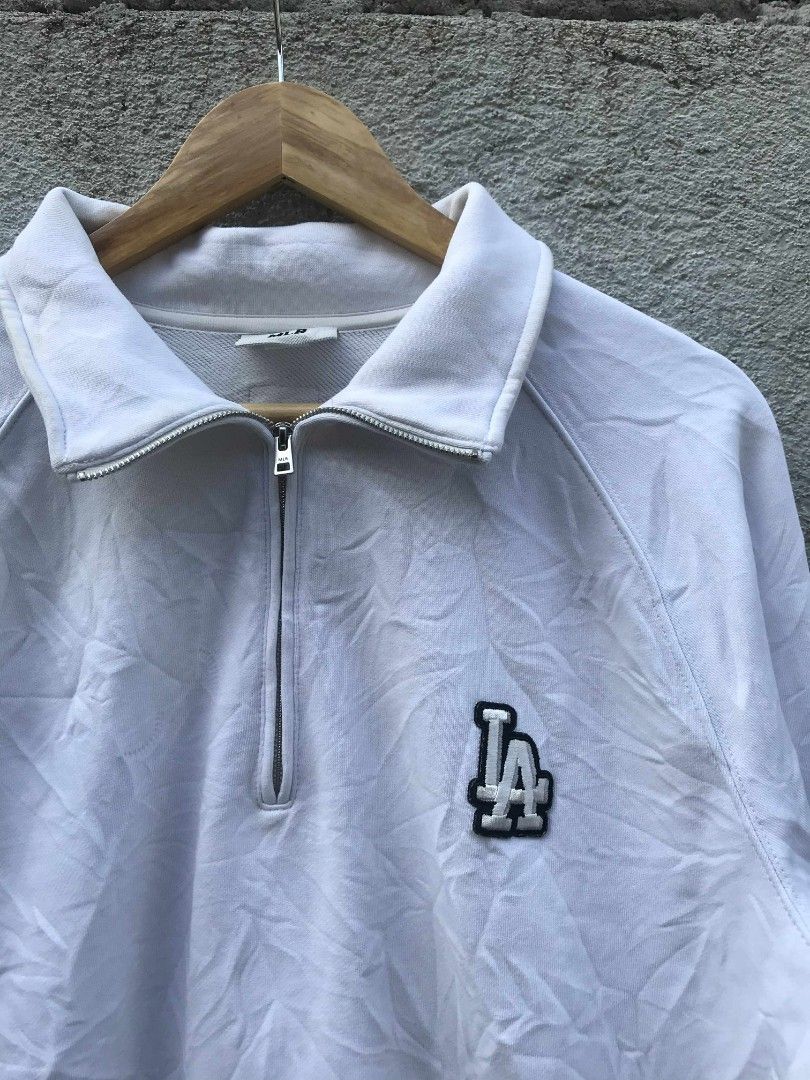 MLB LA Dodgers Quarter Zip Sweatshirt White (Category: Coats, Jackets and Outerwear) located in Banga. Submitted by its.zayn11e (Listing ID 1462285654, Image 3). Description: - White MLB quarter zip sweatshirt - Features the iconic LA Dodgers logo on the chest - Stylish raglan sleeves - Made from comfortable material, perfect for everyday wear - Great for casual outings and showing team spirit - Please check all photos for detailed condition.