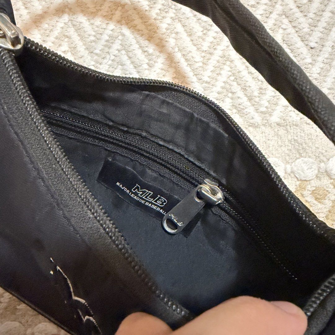 MLB New York Yankees Black Shoulder Bag (Category: Shoulder Bags) located in Batangas. Submitted by prelove.kk (Listing ID 1462402159, Image 3). Description: - Black shoulder bag with official NY Yankees logo. - Secure zip closure. - Interior MLB tag for authenticity. - Compact and small, ideal for carrying essentials. - Comfortable strap for easy wear. - A must-have accessory for any dedicated Yankees fan..