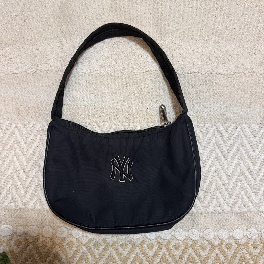 MLB New York Yankees Black Shoulder Bag (Category: Shoulder Bags) located in Batangas. Submitted by prelove.kk (Listing ID 1462402159, Image 1). Description: - Black shoulder bag with official NY Yankees logo. - Secure zip closure. - Interior MLB tag for authenticity. - Compact and small, ideal for carrying essentials. - Comfortable strap for easy wear. - A must-have accessory for any dedicated Yankees fan..