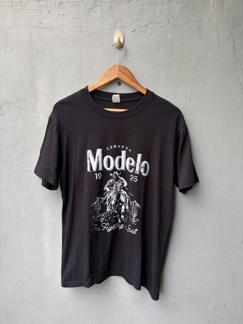 Modelo Merch Tee | Random | Thrifted (Category: Tshirts & Polo Shirts ) located in Pasig City. Submitted by vintagekingdomph (Listing ID 1462375171, Image 1). Description: Modelo Merch Tee Size: M on Tag (Width: 20”, Length: 27.5”) All pieces are THRIFTED / UKAY items. • Please wash items before wearing • Minor signs of use may be present • Actual color may differ depending on lighting • Inspect photos and measurements carefully • Please manage e