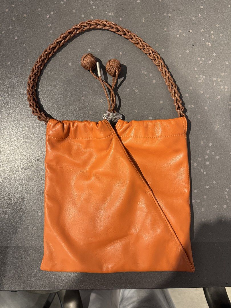 Muunsan Orange Leather Drawstring Handbag with Braided Strap (Category: Shoulder Bags) located in Manila. Submitted by declutterkween14 (Listing ID 1462340028, Image 2). Description: .