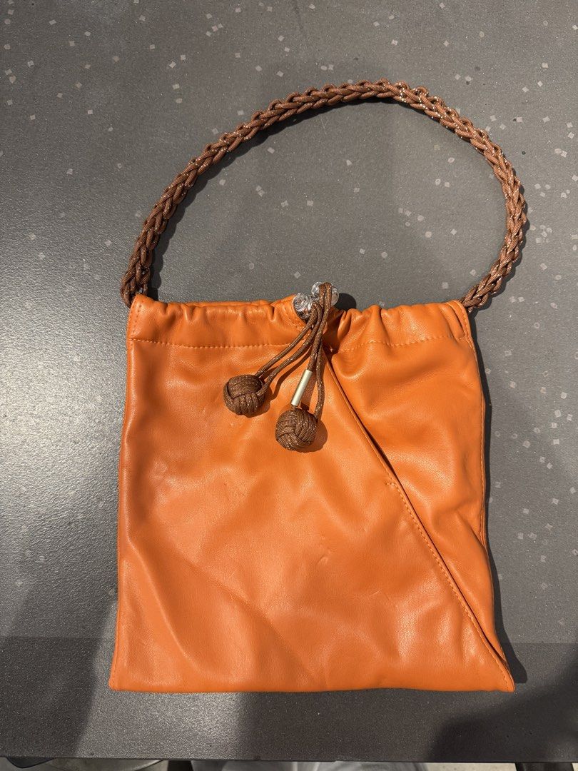 Muunsan Orange Leather Drawstring Handbag with Braided Strap (Category: Shoulder Bags) located in Manila. Submitted by declutterkween14 (Listing ID 1462340028, Image 1). Description: .