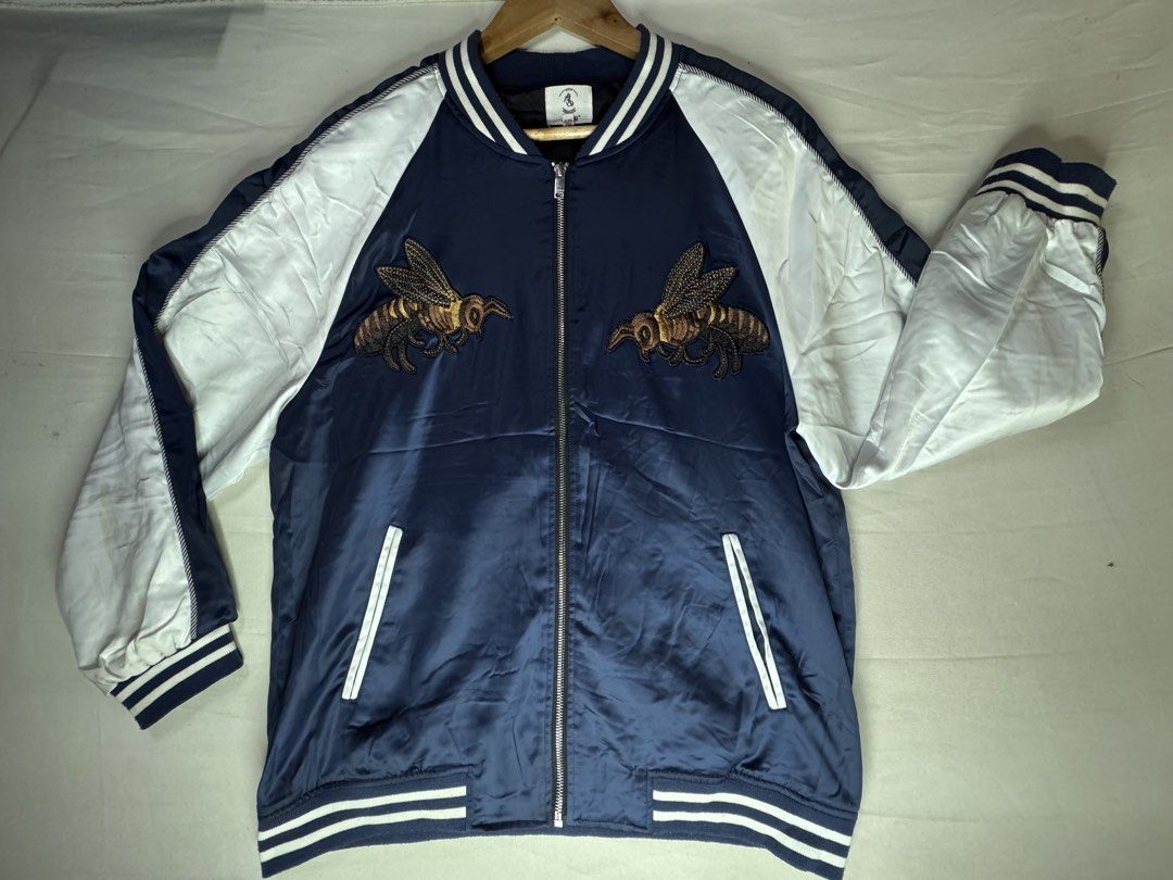 Navy Bomber Jacket with Bee and Snake Embroidery (Category: Coats, Jackets and Outerwear) located in Roxas City. Submitted by patsquarephantz (Listing ID 1462325171, Image 1). Description: - Cool navy bomber jacket - Embroidered bees on front - Snake with text graphic on back - White sleeves - Blue and white striped cuffs and collar - Zipper closure - Perfect statement piece.