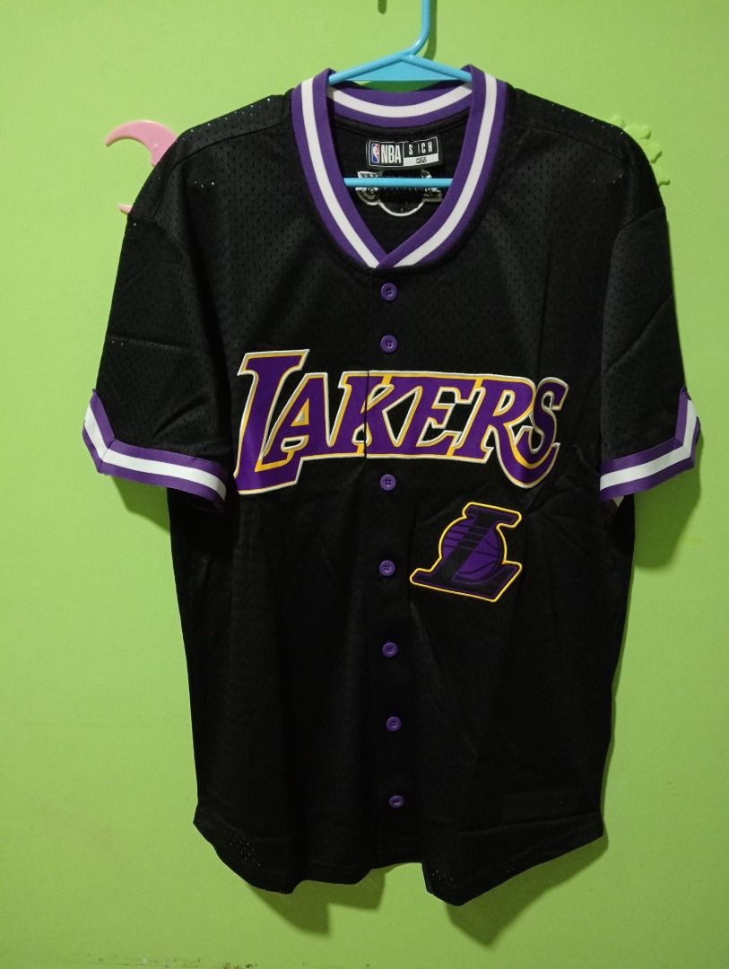 NBA Los Angeles Lakers Baseball Jersey (Category: Activewear) located in Caloocan City. Submitted by yazzielux (Listing ID 1462432026, Image 2). Description: - Black Los Angeles Lakers baseball jersey - Features iconic Lakers logo and name across the chest - Purple and white trim on collar and sleeves - Classic button-up front design - Made with breathable mesh fabric - Size S - Ideal for any dedicated Lakers fan!.