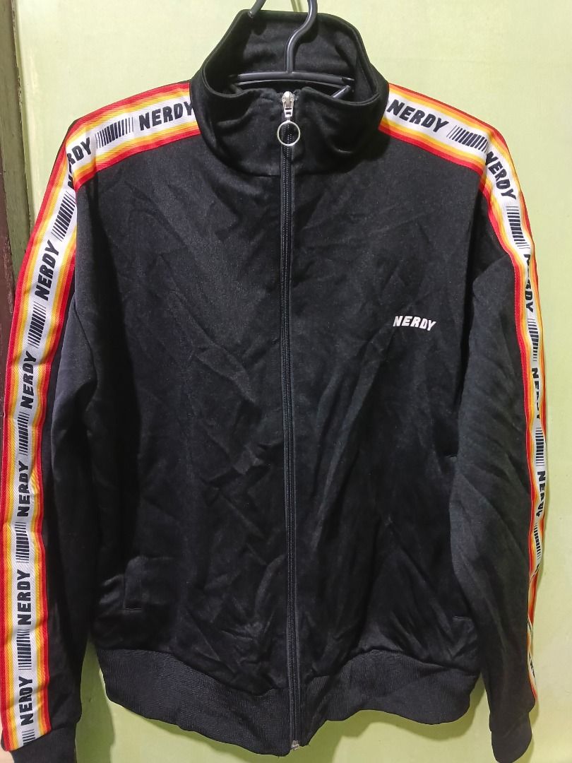NERDY Black Track Jacket with Striped Sleeves (Category: Coats, Jackets and Outerwear) located in Urdaneta. Submitted by fastbird.12354e (Listing ID 1462327290, Image 1). Description: - Dimension: 22 x 26 - Brand: NERDY - Color: Black - Design: Brand name on chest and sleeves, colorful stripe detail - Features: Full zip front, stand-up collar, ribbed cuffs and hem - Style: Ideal for casual wear or sports.