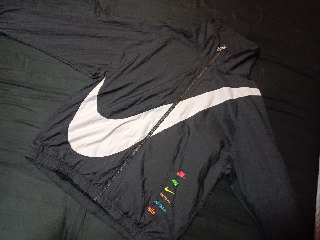 Nike Big Swoosh Windbreaker Jacket Black (Category: Coats, Jackets and Outerwear) located in Manila. Submitted by 4amnlthriftstore (Listing ID 1462329313, Image 2). Description: - Black Nike windbreaker jacket - Features iconic big swoosh on front and back - Multiple small Nike logos and slogans on lower front - Lightweight material, ideal for casual wear or light workouts - Zipper closure - A must-have for any Nike enthusiast.