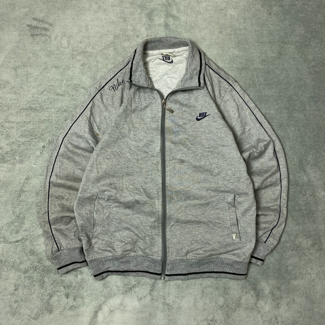 Nike Grey Track Jacket (Category: Hoodies) located in Imus. Submitted by lsthriftsaig (Listing ID 1462323848, Image 1). Description: Nike Grey Track Jacket Size tag: XL Length: 26 Width: 21.5 Issue(s): None Condition: 10/10.