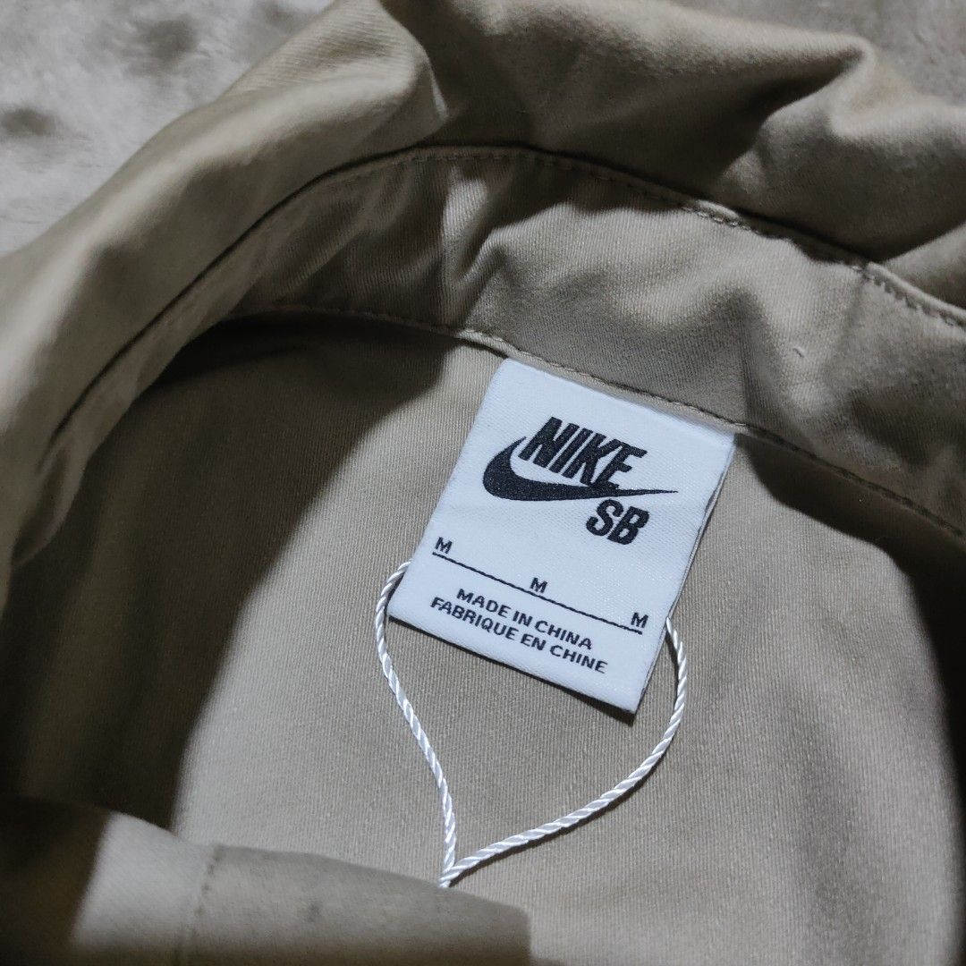 Nike SB Khaki Button Up Shirt (Category: Tshirts & Polo Shirts ) located in Taguig. Submitted by actualizeboutique (Listing ID 1462350984, Image 3). Description: - Khaki Nike SB button-up shirt - Tagged size M - Two chest pockets - Small embroidered Nike swoosh - Made in China - Note: Faint marks on collar area, please check photos for details..