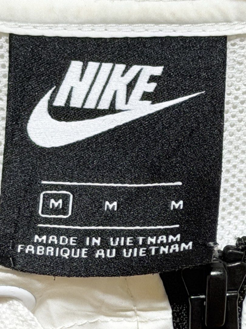 Nike Windbreaker Jacket White Black Size M (Category: Coats, Jackets and Outerwear) located in Las Pinas. Submitted by __dayaaaaan21 (Listing ID 1462397571, Image 3). Description: - Classic Nike windbreaker jacket - Size: Medium (M) - Color: White body with black lower half and sleeves - Features iconic Nike swoosh logo on chest - Hooded design with full zip closure - Drawstring at hem for adjustable fit - Made in Vietnam.