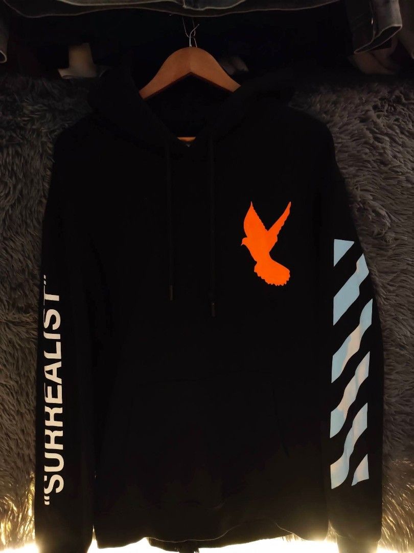 OFF-WHITE "Main Label" Surrealist (Category: Coats, Jackets and Outerwear) located in Quezon City. Submitted by rezno (Listing ID 1462435529, Image 2). Description: - Authentic OFF-WHITE Hoodie - Color: Black - Size: L - XL 23 x 29 - Back Graphic: Iconic cloud design - Front Graphic: Orange bird - Left Sleeve Detail: 'Surrealist' text - Right Sleeve Detail: Diagonal stripes - Origin: Made in Portugal.