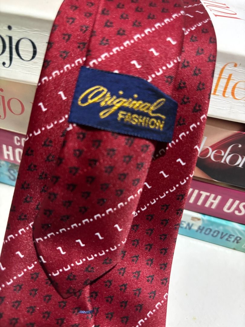 Original Fashion Red Patterned Necktie (Category: Ties) located in Baao. Submitted by apr1979 (Listing ID 1462405986, Image 2). Description: - Classic red necktie - Features a repeating pattern of small dark shapes and diagonal white lines - Blue inner lining - Label: 'Original Fashion' - Ideal for formal wear, business, or special occasions - Adds a pop of color to your outfit.
