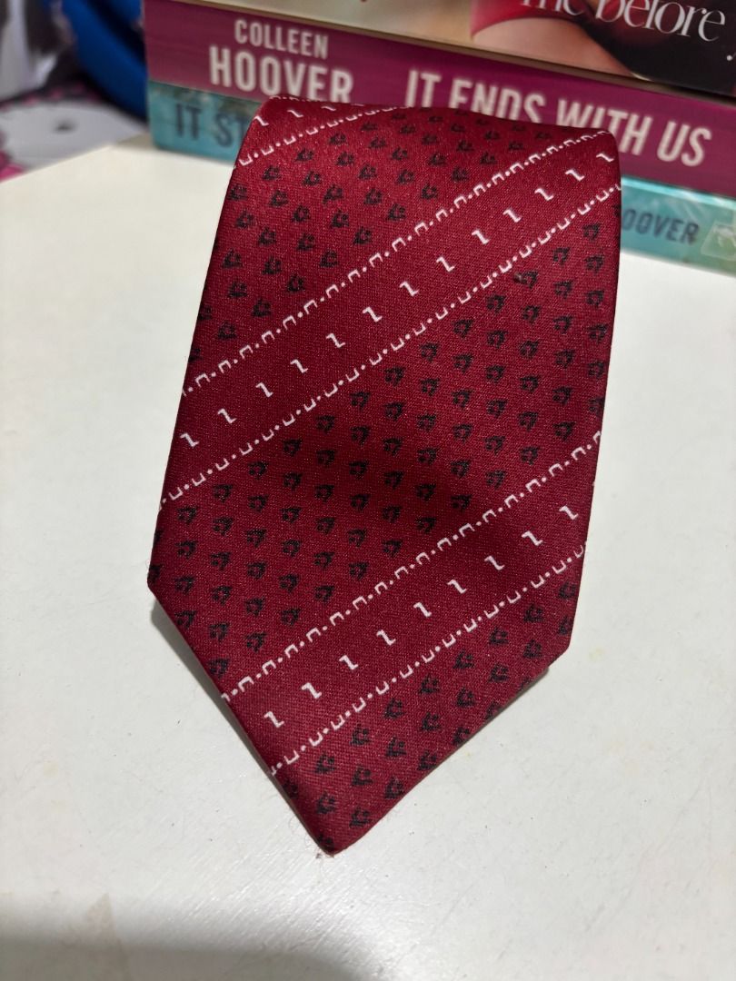Original Fashion Red Patterned Necktie (Category: Ties) located in Baao. Submitted by apr1979 (Listing ID 1462405986, Image 3). Description: - Classic red necktie - Features a repeating pattern of small dark shapes and diagonal white lines - Blue inner lining - Label: 'Original Fashion' - Ideal for formal wear, business, or special occasions - Adds a pop of color to your outfit.