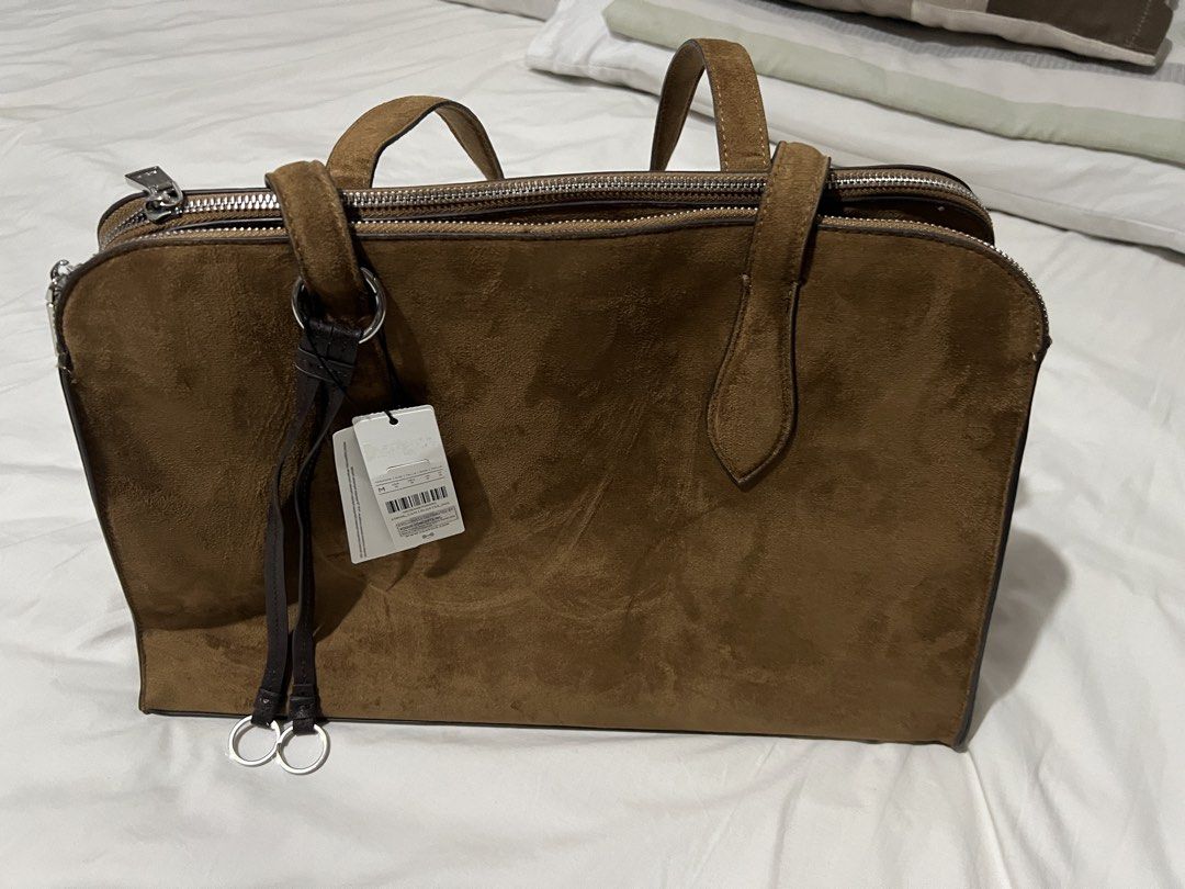 Parfois Brown Suede Tote Bag (Category: Tote Bags) located in Pasig City. Submitted by shop.rdm (Listing ID 1462391143, Image 1). Description: - Stylish brown suede tote bag - Two main zippered compartments - Central compartment with snap closure - Interior card slots - Interior zip pocket - Durable, sturdy handles - Brand new with original tags attached.