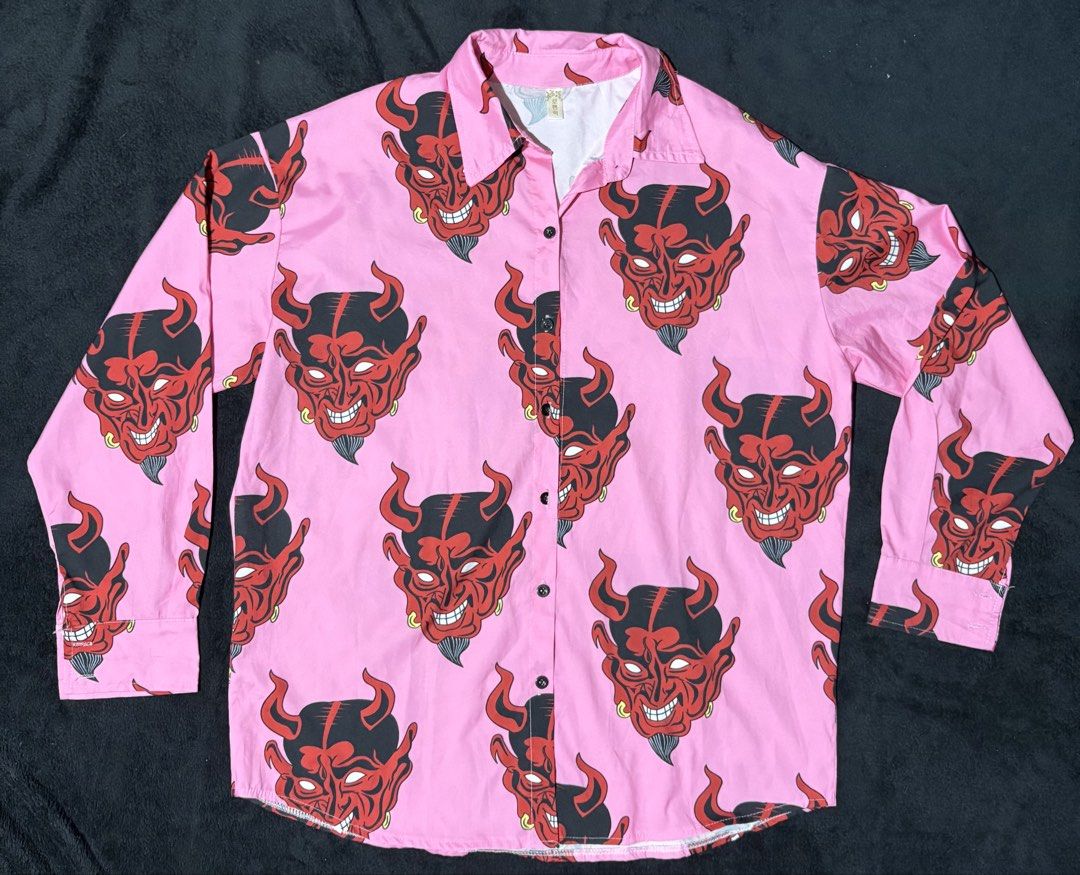 Pink Devil Face Print Long Sleeve Button Up Shirt (Category: Shirts) located in Pasay City. Submitted by wornfitsco (Listing ID 1462284894, Image 1). Description: 😈 Devil AOP MGK Vibe Longsleeve All-over-print long sleeve with edgy rock-inspired aesthetic. Gives major Y2K and MGK vibes. 📏 25 x 30 ✨ Condition: New 💰 ₱300 ⚡ No issues.
