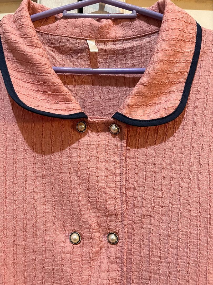 Pink Puff Sleeve Blouse (Category: Blouses) located in Quezon City. Submitted by bunniezen (Listing ID 1462356107, Image 2). Description: - Pink blouse with a unique textured fabric. - Puff sleeves with elegant navy trim. - Classic Peter Pan collar, also accented with navy trim. - Stylish double-breasted button front adorned with delicate pearl buttons. - Effortlessly pairs with skirts or trousers for a chic look. - Easy to style for various occa