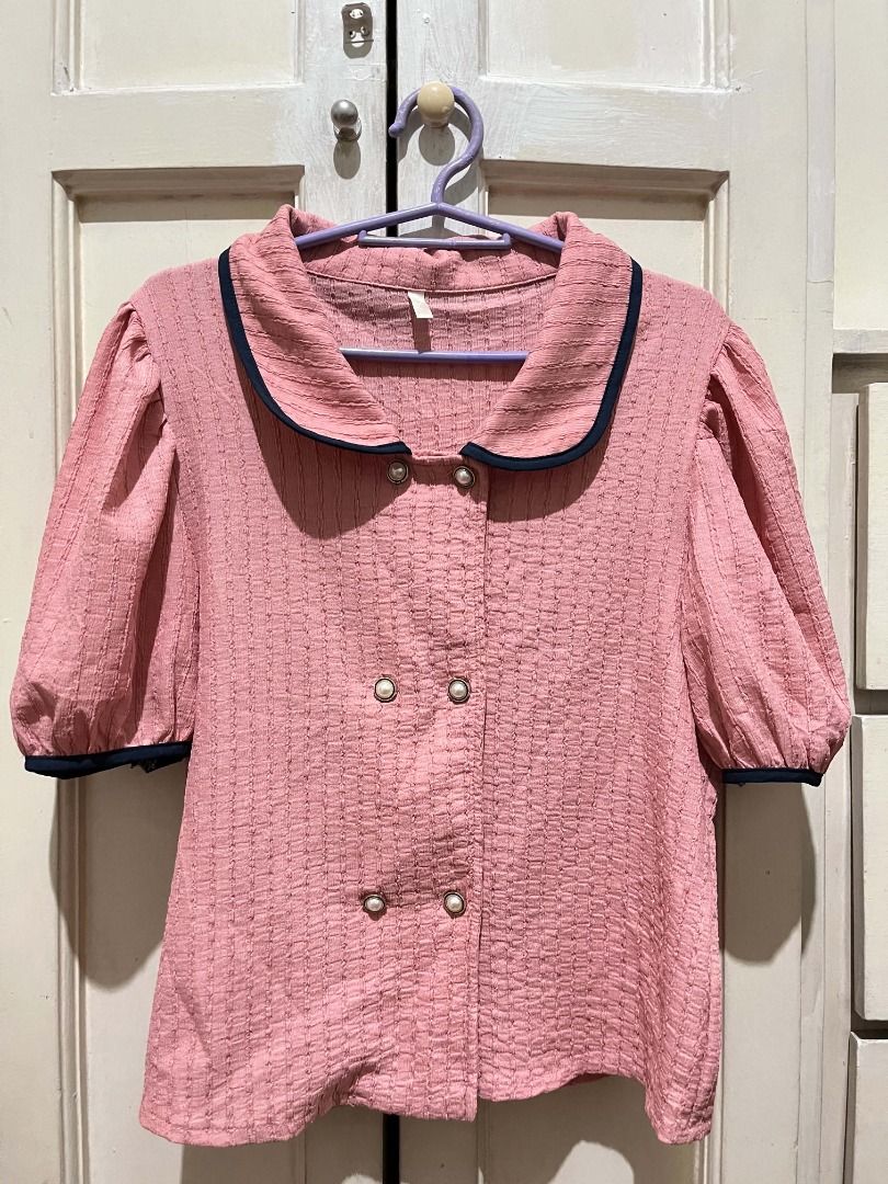 Pink Puff Sleeve Blouse (Category: Blouses) located in Quezon City. Submitted by bunniezen (Listing ID 1462356107, Image 1). Description: - Pink blouse with a unique textured fabric. - Puff sleeves with elegant navy trim. - Classic Peter Pan collar, also accented with navy trim. - Stylish double-breasted button front adorned with delicate pearl buttons. - Effortlessly pairs with skirts or trousers for a chic look. - Easy to style for various occa