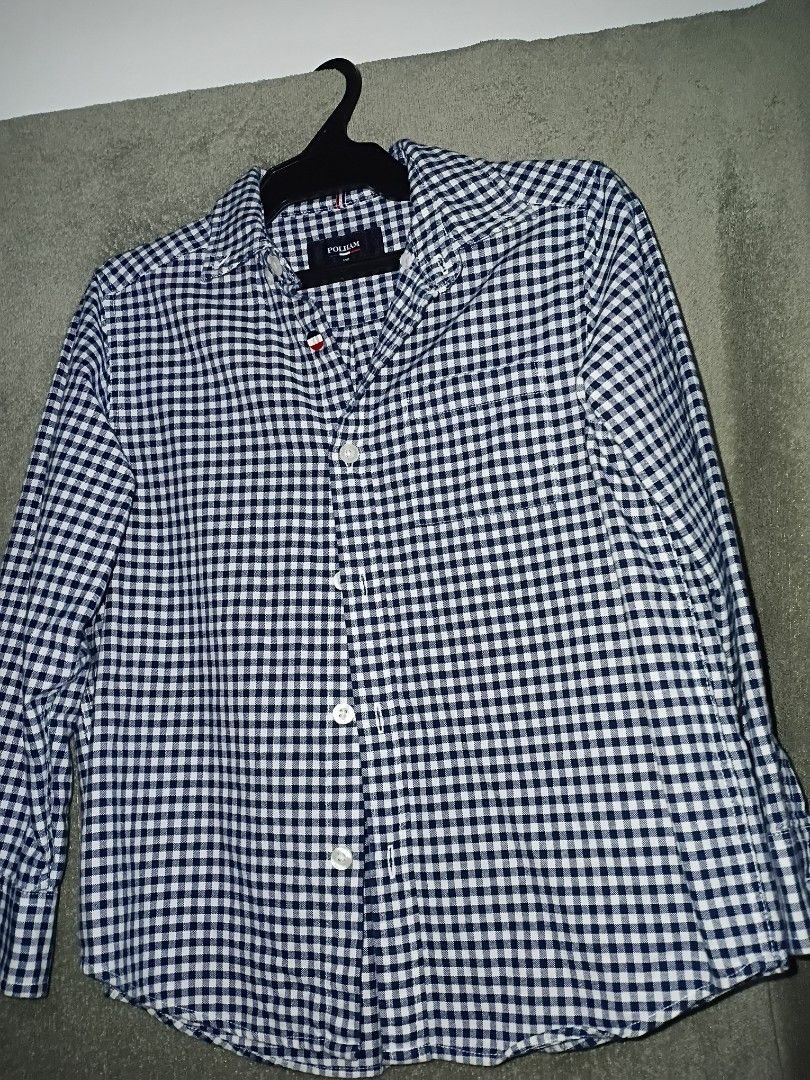 POLHAM Gingham Check Long Sleeve Shirt (Category: Tshirts & Polo Shirts ) located in Las Pinas. Submitted by brighteagle_f7df30 (Listing ID 1462386165, Image 2). Description: - Brand: POLHAM - Style: Long sleeve shirt - Pattern: Classic navy and white gingham check - Closure: Button-up front with white buttons - Size: Tagged 120 - Occasion: Versatile for casual wear or dressing up.