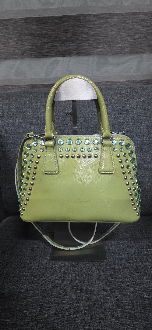 Prada Lime Green Patent Leather Studded Handbag (Category: Shoulder Bags) located in General Trias. Submitted by roselle2230 (Listing ID 1462416326, Image 2). Description: - Eye-catching lime green patent leather handbag - Adorned with sparkling green crystals and silver studs - Secure zipper closure - Features multiple interior compartments for organization - Includes a detachable strap for versatile carrying options - Perfect for adding a bold 