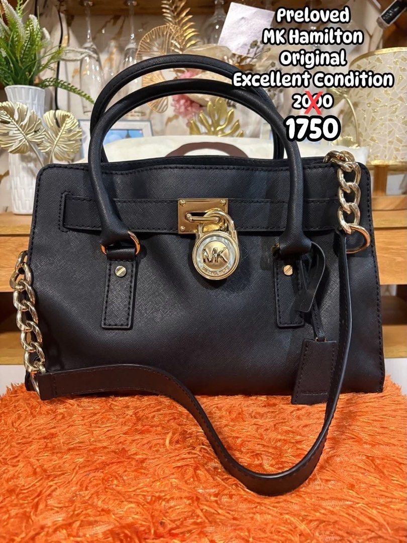 Preloved Michael Kors Hamilton Original Black Leather Handbag (Category: Cross-body Bags) located in Manila. Submitted by moshcruz_01 (Listing ID 1462315569, Image 1). Description: Preloved Michael Kors Hamilton handbag. Original piece. Black leather with gold chain details. Lock closure. Comes with a crossbody strap. Bought it a while back but barely used. Still looks great..