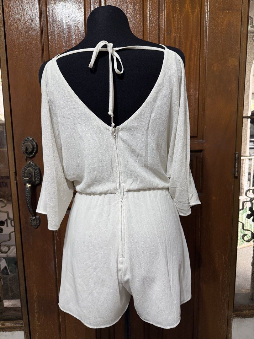 Premier Amour White Cold Shoulder Romper Size 4 (Category: Rompers) located in Manila. Submitted by prelovedshopmnl (Listing ID 1462307488, Image 2). Description: - White cold shoulder romper by Premier Amour - Flattering V-neckline with wrap-style front - Comfortable elasticated waist - Stylish tie detail at the back with zipper closure - Size 4.
