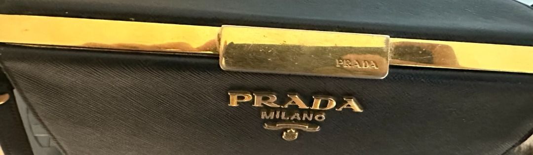 Pre-Owned Authentic Prada Light Frame Safiano Leather Bag (Category: Luxury Bags & Wallets) located in Pasay City. Submitted by sofiadeclutter_10 (Listing ID 1462337868, Image 2). Description: This is an pre-owned authentic PRADA Saffiano City Calfskin Light Frame Bag in Black. This chic bag is crafted from stylish saffiano cross-grain leather in black. The bag features an adjustable shoulder strap and gold hardware. The top opens to a black leat